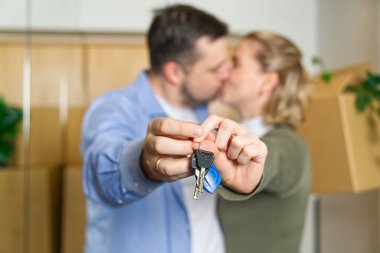 Couple showing keys to new apartment. real estate mortgage, loan concept. moving in new house. Young smiling couple holding their new house keys. first own apartment or house.