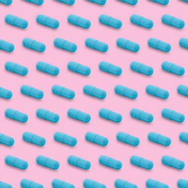Gel capsule seamless pattern. Blue capsule shaped medicine. pharmacy concept. food supplement. Capsule pills pattern on a pink background
