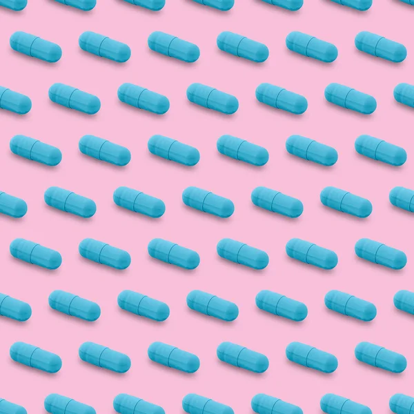 Gel capsule seamless pattern. Blue capsule shaped medicine. pharmacy concept. food supplement. Capsule pills pattern on a pink background