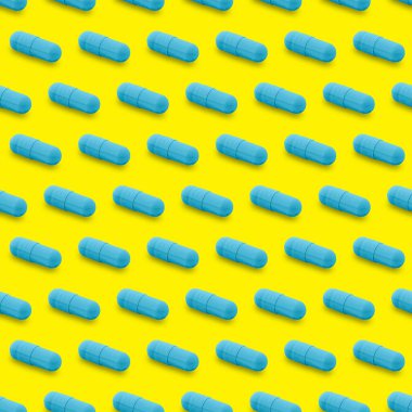 Gel capsule seamless pattern. Blue capsule shaped medicine. pharmacy concept. food supplement. Capsule pills pattern on a yellow background