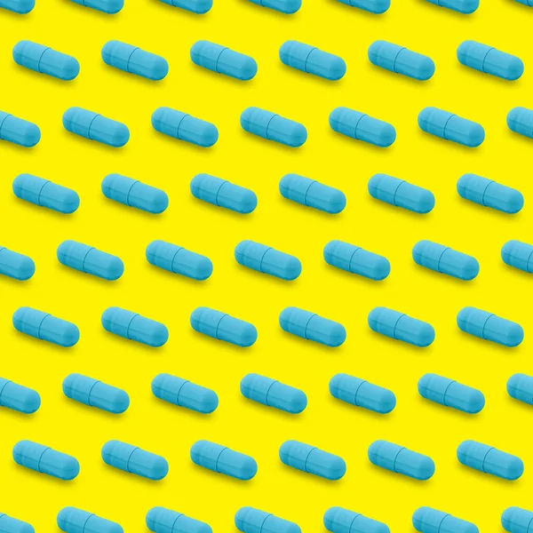Gel capsule seamless pattern. Blue capsule shaped medicine. pharmacy concept. food supplement. Capsule pills pattern on a yellow background