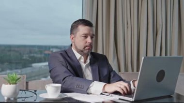 Happy businessman working on laptop in home office. financial investor working in the office. Accountant working on consolidated financial report of corporate operations.