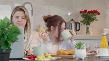 Young family with school kids have fun at breakfast time. Happy family eating healthy breakfast. Quality time with Family in kitchen eating together. Family Using Digital Devices At Breakfast