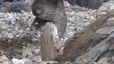 İnşaat makineleri betonu kırıyor. Hidrolik baskı ile kazıcı, matkap makinesi betonu kırıyor.