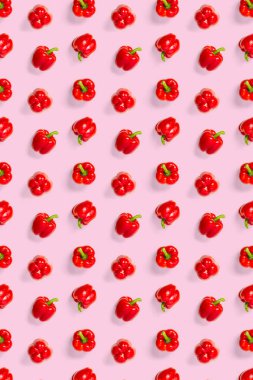 Pembe arka planda Bulgar kırmızı biberi. Paprikadan arkaplan, düz yatay dikişsiz desen değil