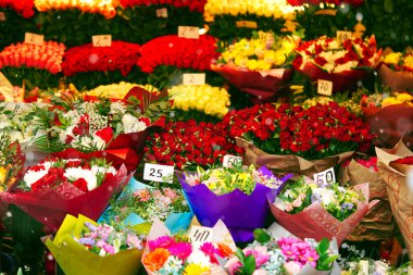Çiçekçinin önünde renkli güller sergileniyor. Yerel pazarda satılık çiçek aranjmanları. Çiçekler Anneler Günü 'nden önce satışta, 8 Mart.