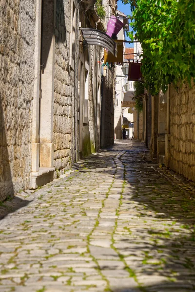 stock image Narrow street with stone houses. Old houses and old narrow alley in Trogir, Croatia, Europe. Streets in old town.