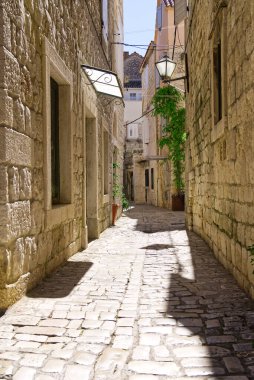 Taş evlerle dolu dar bir sokak. Trogir, Hırvatistan ve Avrupa 'da eski evler ve eski dar bir sokak. Eski kasabadaki sokaklar.