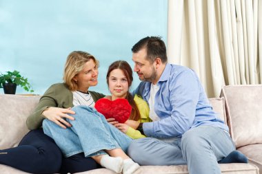 Happy family with kids sit on sofa in living room have fun using laptop together, smiling parents rest on couch enjoy weekend with childrens laugh watch video on computer at home