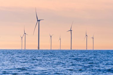 Kıyıdan uzak yel değirmeni çiftliği. Hollanda 'nın güzel ve aydınlık bir gününde yel değirmenleri denizde izole edildi. Yeşil enerji Flevoland küresel ısınma yel değirmenleriyle yenilenebilir enerji