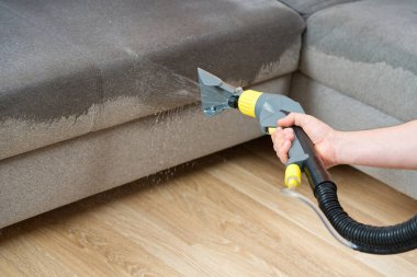 Kuru temizlemeci çalışanı mobilyalardaki toprağı temizliyor, yakın plan, elektrikli süpürge ile profesyonel ekipmanla temizliyor. Kanepeyi yıkama temizliği ile kapatıyoruz..
