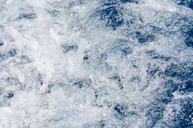 Beyaz dalgalı soyut mavi deniz suyu. Dalgalı ve köpüklü mavi deniz dokusu. Dalgalı derin turkuaz ve mavi Akdeniz. Deniz suyu manzarası.