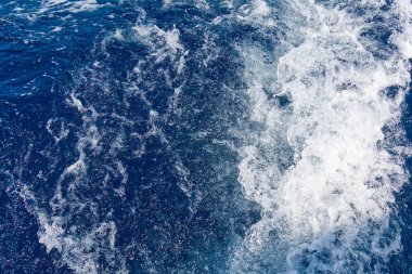 Beyaz dalgalı soyut mavi deniz suyu. Dalgalı ve köpüklü mavi deniz dokusu. Dalgalı derin turkuaz ve mavi Akdeniz. Deniz suyu manzarası.