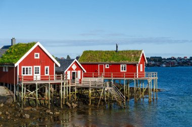 Reine 'de yaz, Lofoten Adaları, Norveç. Popüler turizm merkezi. Klasik Norveç Otelleri 'nin Rorbuer adlı ahşap kırmızı kulübesi olan eski balıkçı köyü.