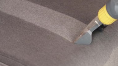 Kuru temizlemeci çalışanı mobilyalardaki toprağı temizliyor, yakın plan, elektrikli süpürge ile profesyonel ekipmanla temizliyor. Kanepeyi yıkama temizliği ile kapatıyoruz..