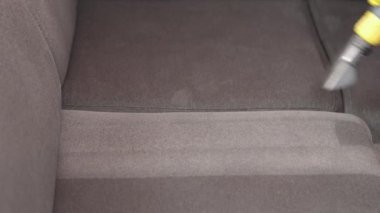 Kuru temizlemeci çalışanı mobilyalardaki toprağı temizliyor, yakın plan, elektrikli süpürge ile profesyonel ekipmanla temizliyor. Kanepeyi yıkama temizliği ile kapatıyoruz..