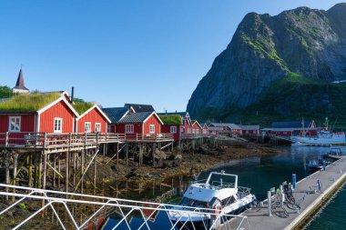 Reine 'de yaz, Lofoten Adaları, Norveç. Popüler turizm merkezi. Klasik Norveç Otelleri 'nin Rorbuer adlı ahşap kırmızı kulübesi olan eski balıkçı köyü.