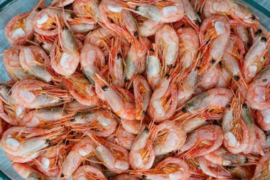 Close up on boiled big sea prawns or shrimps on glass plate. seafood, dieting food. Seafood on the counter. Photo of shrimp in the supermarket. Wholesale of fish. Frozen shrimp