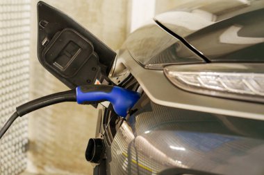 Yeraltı otoparkındaki şarj istasyonunda elektrikli arabaları şarj etmek. Ekolojik enerji sistemleri kavramı. Şarj istasyonundaki yeraltı otoparkında elektrikli arabalar.
