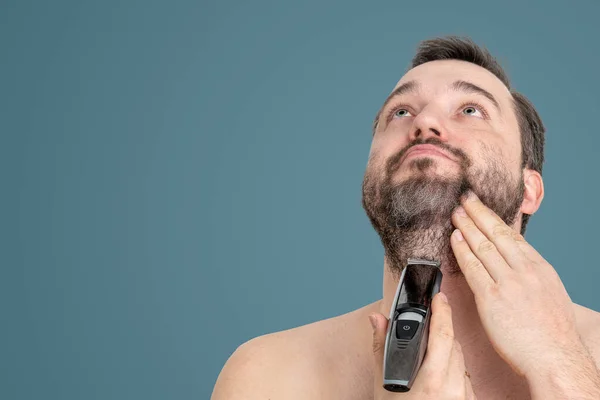 unshaven young man perfect skin hold electric razor shaving, isolated. Skin care healthcare cosmetic procedures concept. Grooming for the modern man. handsome man using electric razor