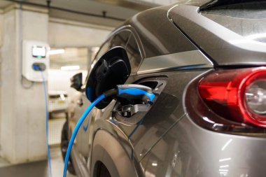 Yeraltı otoparkındaki şarj istasyonunda elektrikli arabaları şarj etmek. Ekolojik enerji sistemleri kavramı. Şarj istasyonundaki yeraltı otoparkında elektrikli arabalar.