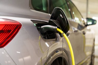 Yeraltı otoparkındaki şarj istasyonunda elektrikli arabaları şarj etmek. Ekolojik enerji sistemleri kavramı. Şarj istasyonundaki yeraltı otoparkında elektrikli arabalar.
