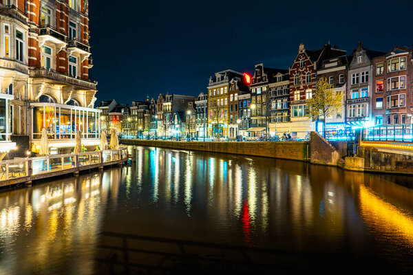 Illuminated Canals and Riverside Delights: Exploring Amsterdam After Dark. Captivating Cityscape of Amsterdam at Night: A Delightful Blend of Tradition and Modernity