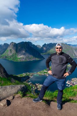 Rahatlamış yürüyüşçü Norveç 'teki Lofoten adalarının fiyortlarında ve dağ zirvelerinde çarpıcı manzaralardan hoşlanır.