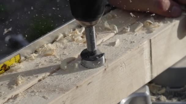 木の穴をあける フライスカッターを使用している労働者 カウンターシンクドリルビットは 穴にシンクを作る 男は木製の板に穴を開けるために掘削機を使う — ストック動画
