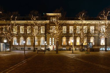 Geceleri Hollanda, Lahey 'in büyüleyici şehrini keşfedin, yıldızlı gökyüzünün altında parlayan parlak ışıklarla büyüleyici ve huzurlu bir atmosfer yaratın..