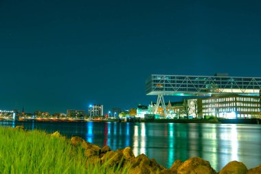 Rotterdam 'daki iş merkezinin büyüleyici bir gece manzarası, şehrin altında yükselen uzun, aydınlık gökdelenler. Işıl ışıl şehir ışıkları Büyüleyici şehir siluetine.
