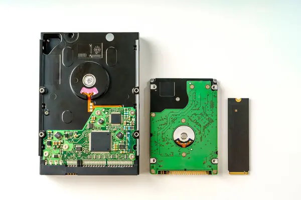 stock image The image displays three distinct types of electronic storage devices including a hard disk drive, a solid-state drive, and a flash drive. Each device is isolated against a clean white background.