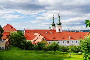 Yeşil ağaçları ve Çek Cumhuriyeti 'nin Cesky Krumlov şehrinde çimenliği olan yemyeşil bir bahçeyle çevrili kırmızı çatı manastırı binaları. Seyahat, turizm, tarih, kültür ve yaz tatilleri için ideal.