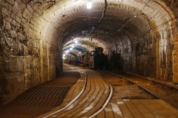 Eski terk edilmiş bir maden tünelinde paslı metal raylar ve engebeli taş duvarlar var. Karanlık ve ürkütücü bir atmosfer yaratarak tarih ve gizem hissi uyandırıyor..