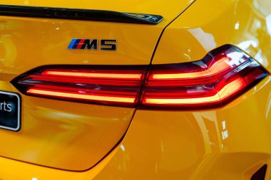 Münih, Almanya, 16.07.2024 - Görüntü, park yerinde park edilmiş modern sarı bir BMW spor arabanın arka tarafını gösteriyor, şaşaalı LED arka ışıkları ve dikkat çeken şık bir tasarımı var..