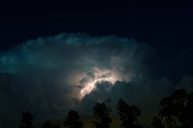 Hollanda 'da çarpıcı bir doğa olayı. Gece gökyüzü bir kümülonimbus bulutunun yıldırımıyla aydınlanır yere çarpar ve doğanın dramatik gücünü gösterir..