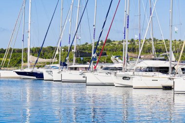 Serin bir marina, yemyeşil ve mavi gökyüzü ile çevrili kristal berrak sularda demirli çeşitli yatları barındırır, rahatlama ve macera için mükemmel bir ortam yaratır..