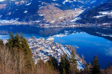 Karla kaplı dağlarla çevrili bir vadiye kurulmuş güzel bir göl köyü. Gökyüzü puslu bulutlarla mavidir ve köy geleneksel evleri ve kiliseleriyle cazibeyle doludur..