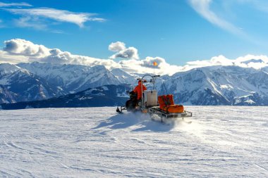 Kar motosikleti beyaz karlı bir zeminde izole bir şekilde duruyor. Bu modern araç karlı bölgelerde eğlence ve ulaşım için mükemmeldir, her yaştan insana eğlence sağlar..