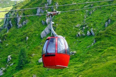 Yeşil manzaralı bir dağ manzarasında teleferikle yukarı çıkmak. Yukarıdan dağ tepelerinin ve vadilerin manzarasının tadını çıkarıyorum. Teleferik bölgede popüler bir turistik merkezdir..