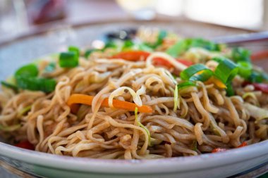 Taze sebzeler ve lezzetli lezzetlerle dolu lezzetli bir tabak kızarmış eriştenin tadını çıkarın. Tatmin edici bir yemek. Yemek için mükemmel. Renk ve lezzetle dolu..