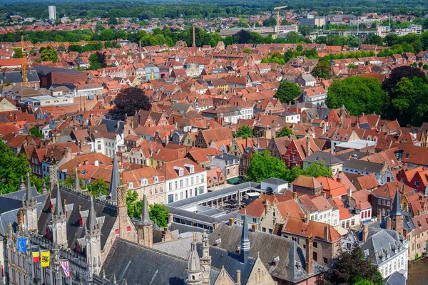 Brugge, Belçika 'nın cazibesini, ikonik kırmızı kiremit çatılar, tarihi binalar ve ortaçağ mimarisini vurgulayan bu hava manzarasıyla yaşayın. Avrupa seyahatini yansıtan güzel bir sahne.