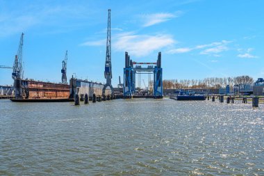Rotterdam, Hollanda 'daki denizcilik sanayiini inceleyin, vinçlerin ve liman altyapısının yer aldığı bu görüntü Rotterdam' daki nakliye ve rıhtım çalışmalarını ön plana çıkarıyor..