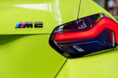 Münih, Almanya, 29.06.2024 - Canlı yeşil bir BMW M2 'nin çarpıcı yakın çekimi, benzersiz stop lambası tasarımı ve M2 logosu. Araba sevenler ve reklamcılar için ideal..