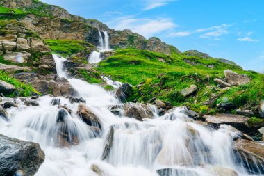 Grossglockner, Avusturya 'da bir şelalenin nefes kesici güzelliğini keşfedin. Kristal berrak sular yemyeşil sularda çağlayarak Avusturya Alplerinin çarpıcı doğasını gözler önüne seriyor..