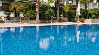 Yeşilliklerle çevrili bu davet edici yüzme havuzunun ferahlatıcı cazibesini hissedin. Tatil için ideal, sakin bir atmosferde rahatlama ve rahatlama için..