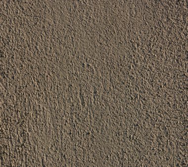 Alçıyla boyanmış renkli duvar kum taneleriyle dolmuş.