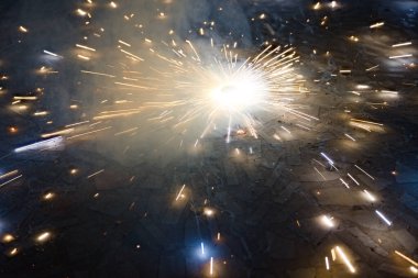 Karanlıkta son sürat dönen tutuşturulmuş yer döndürücü.