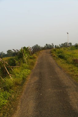 13.11.2022 . Radhikapur, West Bengal, India. black asphalt road beside international border between India and Bangladesh country.