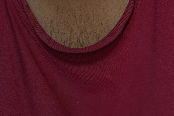 view of chest hair of an asian male wearing a red colored t shirt